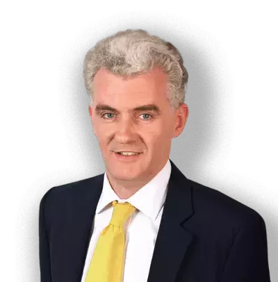 A man wearing a suit with a yellow tie. David O’Mahony is a barrister at 7BR.